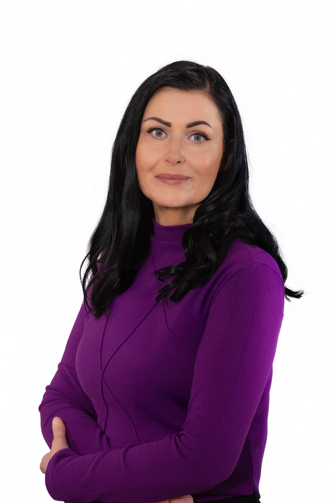 Portrait von Katrin Bench, Arme locker verschränkt, vor hellem Hintergrund